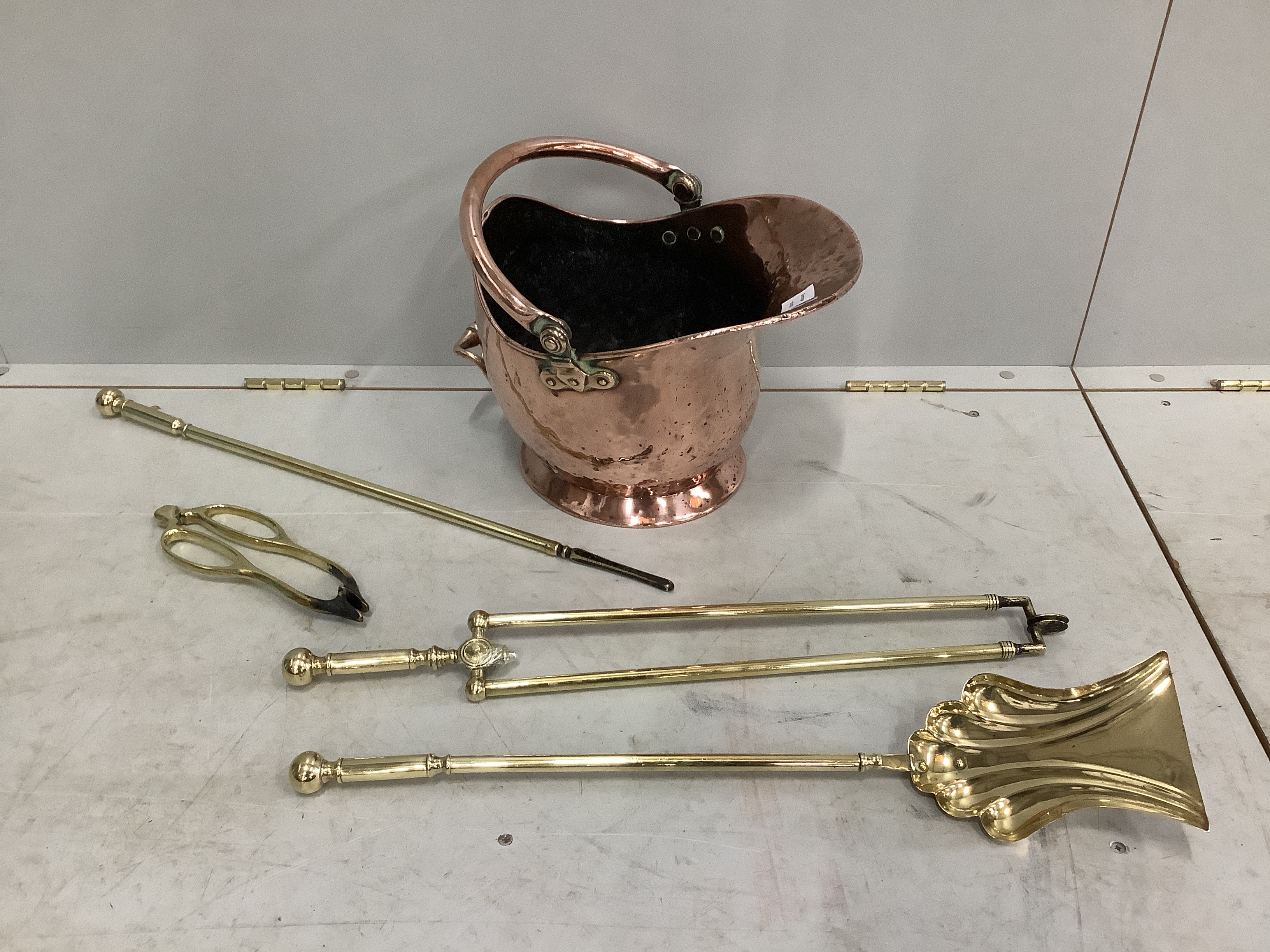 A Victorian copper coal scuttle together with four Victorian brass fire implements